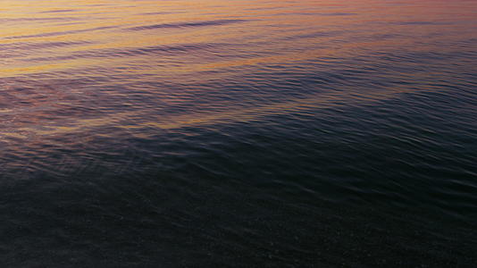 特写平静的海水表面在早晨反射出明亮的粉色日出天空视频的预览图