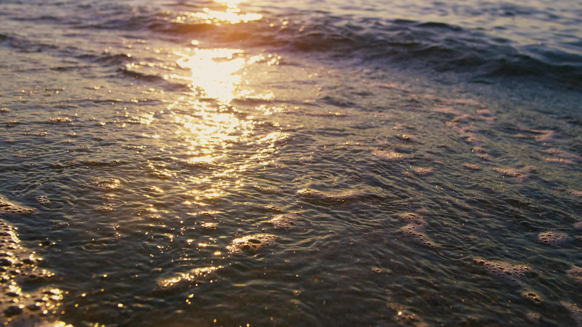 在阳光明媚的早晨平静的海浪溅起了沙滩上的沙滩视频的预览图