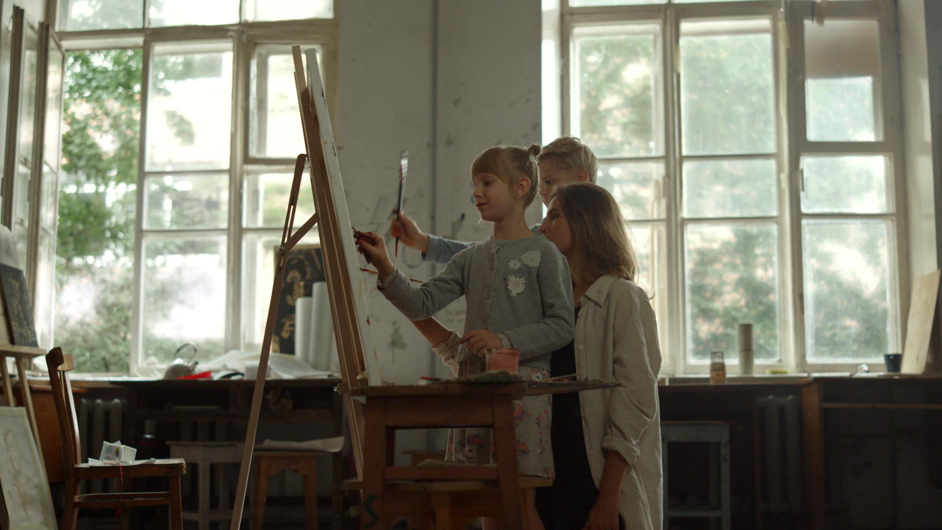 艺术学校的女教师和男女孩一起画画视频的预览图