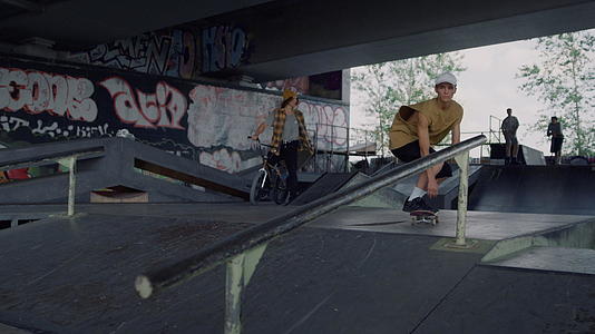 在城市滑板公园的铁路上千禧一代男子表演极限技能视频的预览图