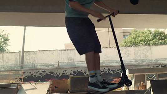 年轻的滑板车骑手在滑板公园表演技巧视频的预览图