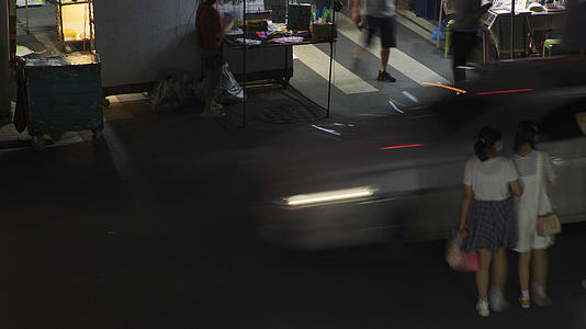 城市夜景道路上行人与川流不息的汽车交通车流4k素材视频的预览图