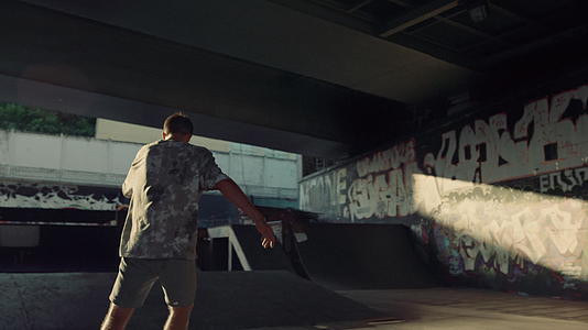 年青的嬉皮士在滑板公园溜冰墙上涂鸦视频的预览图
