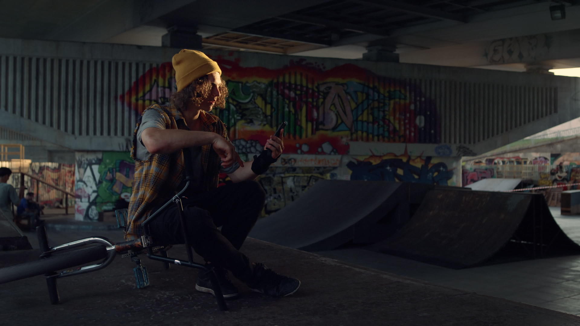 用智能手机在城市滑板公园涂鸦墙上自拍的休闲男人视频的预览图