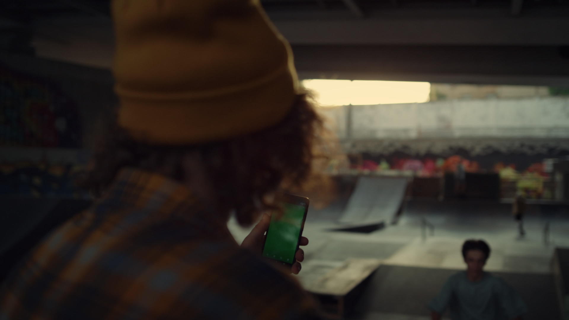 年轻人在滑板公园拍摄手机滑板车骑手训练视频视频的预览图