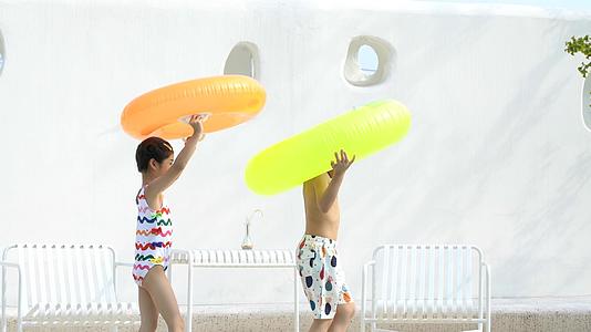 4k夏天儿童游泳抱着泳圈在岸上行走视频的预览图