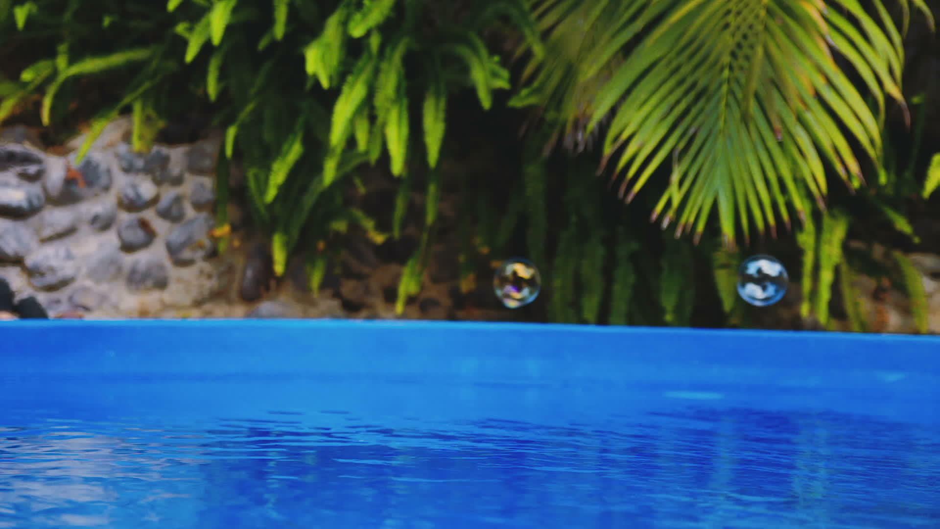 肥皂泡沫电影飞过游泳池的水面视频的预览图
