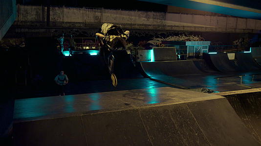 运动型青少年骑手在滑板公园骑滑板车和越野自行车一起跳跃视频的预览图