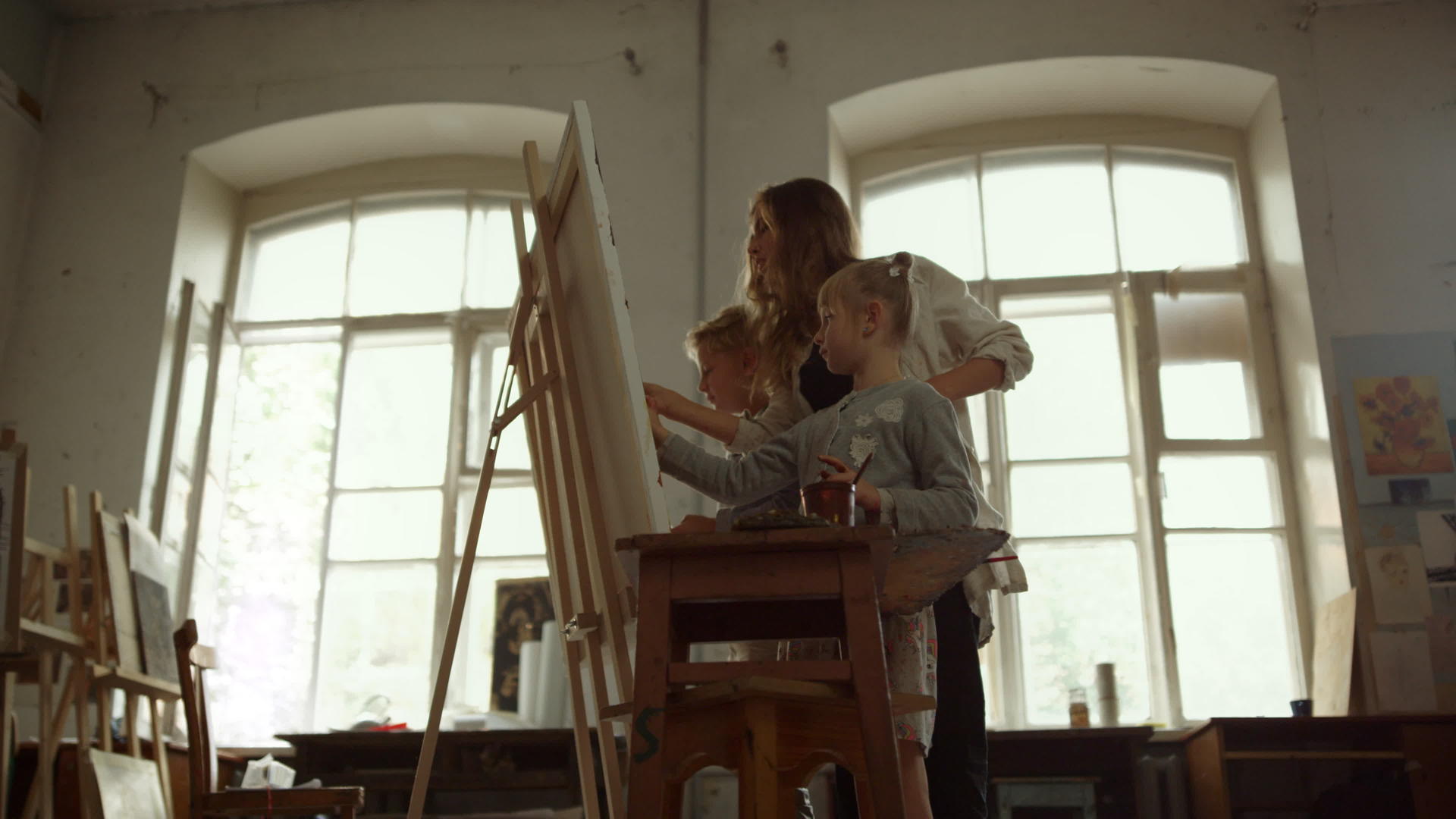 画室里的女画家教孩子画画视频的预览图