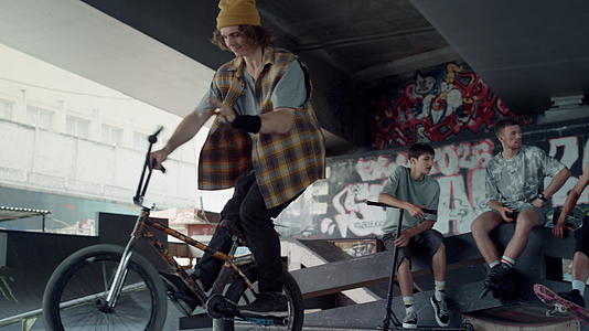 活跃的人们在墙上涂鸦滑板公园练习越野自行车视频的预览图