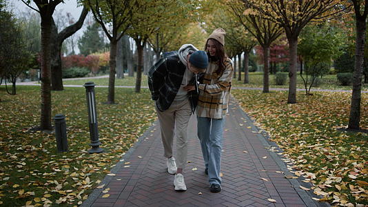 一对幸福的情侣在树丛公园里浪漫地散步视频的预览图