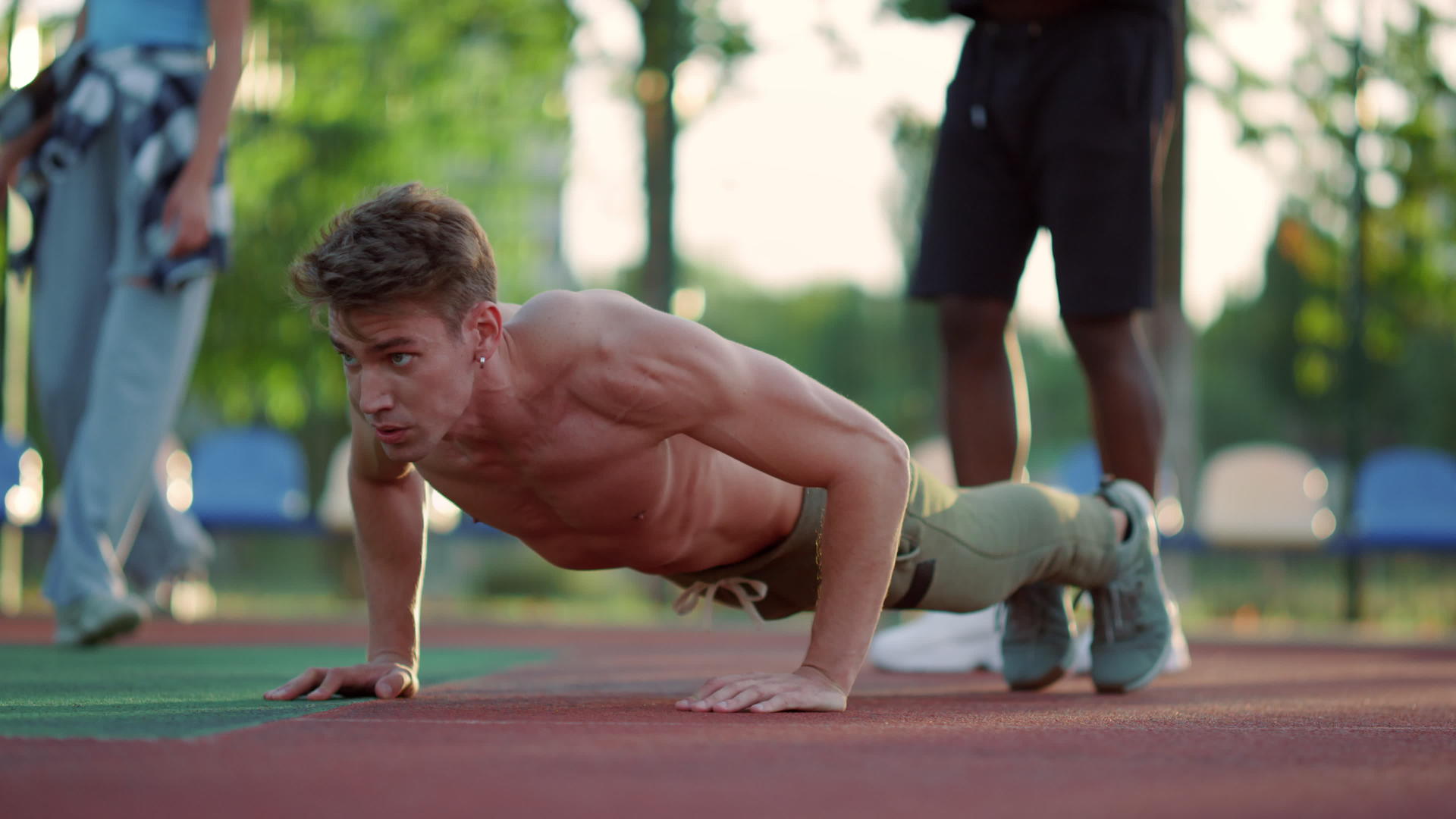 有肌肉的运动员在户外运动场做俯卧撑视频的预览图