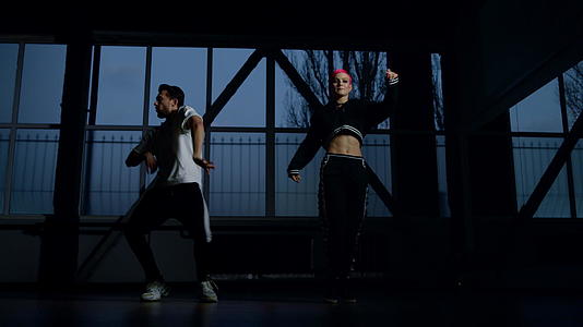 年轻舞者在黑暗的背景下学习嘻哈舞步视频的预览图