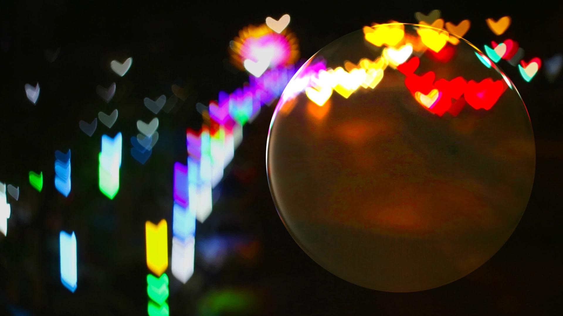 玻璃地板上的水晶球和来自街道的心形彩虹灯反射在球体上视频的预览图