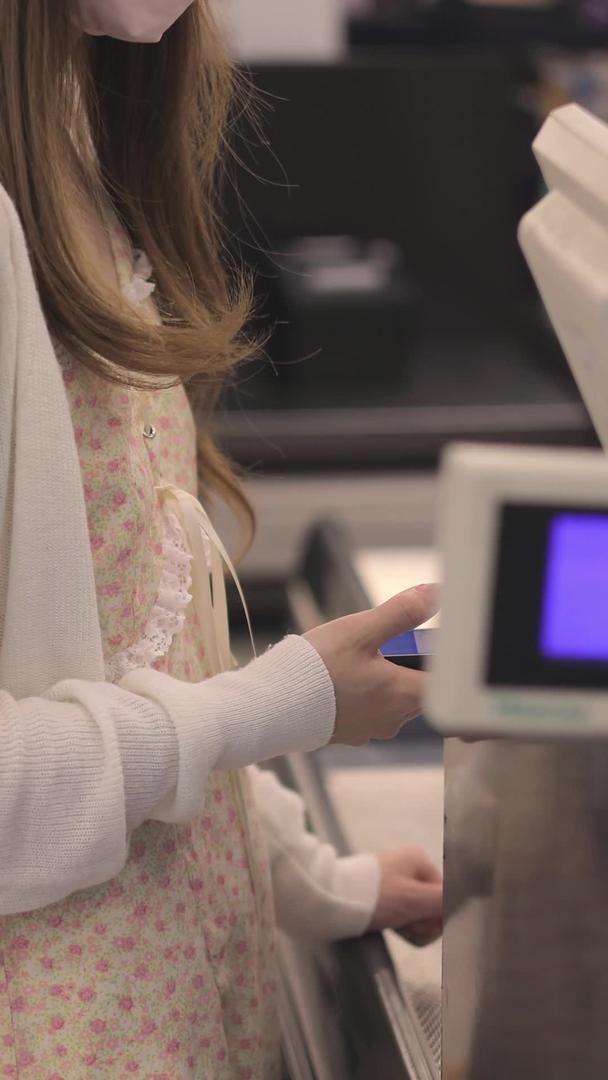 年轻女孩用电子支付超市出口视频的预览图