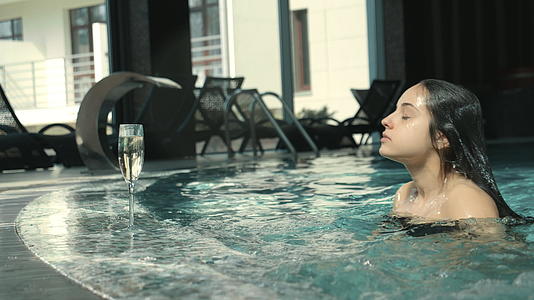 女孩在豪华酒店游泳池游泳视频的预览图
