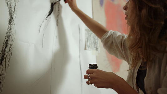 女人在墙上创作艺术品视频的预览图