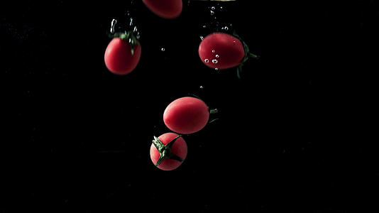 番茄落入水中和空中飞起的升格镜头视频的预览图