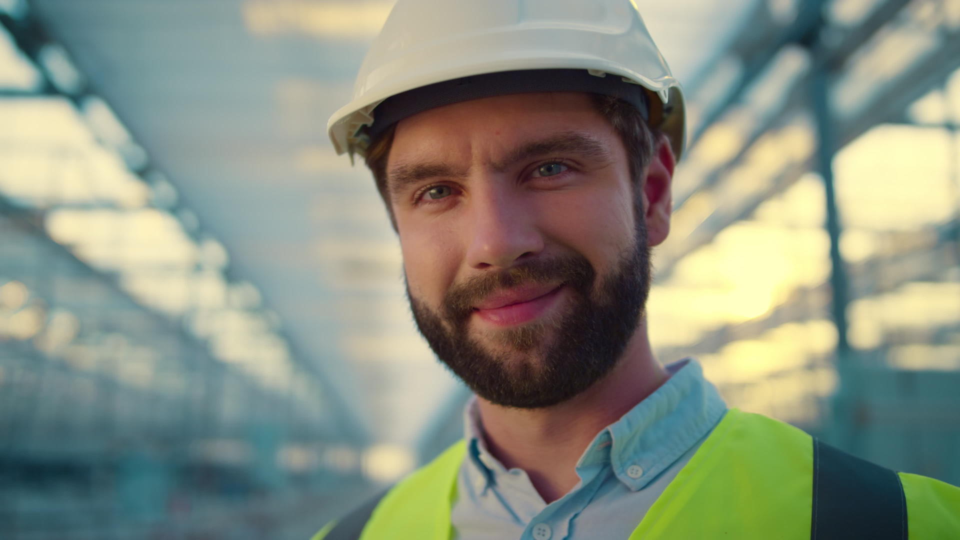 在镜头前肖像工厂工程师微笑着享受戴白色头盔的工作视频的预览图