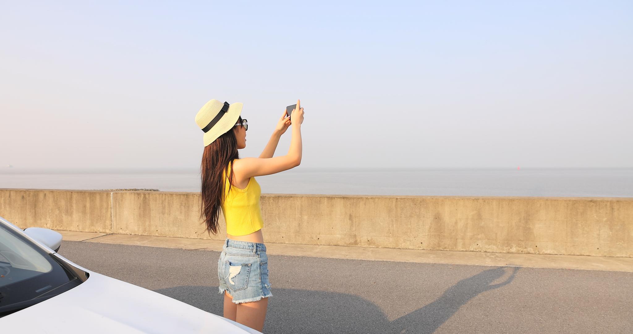 女性自驾出游用手机拍照视频的预览图