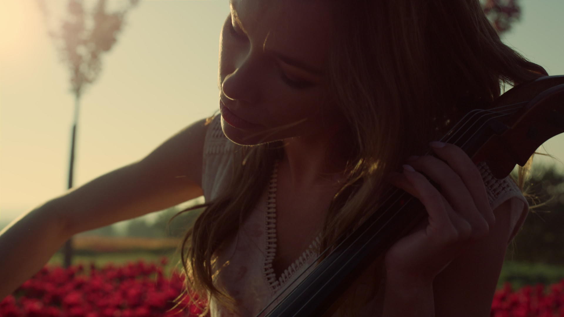 特写镜头激发了夏季花园里年轻女性在户外盛开拉大提琴的灵感视频的预览图