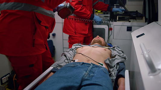 急救医生使用心脏除颤器对救护车内的病人进行心脏除颤器视频的预览图