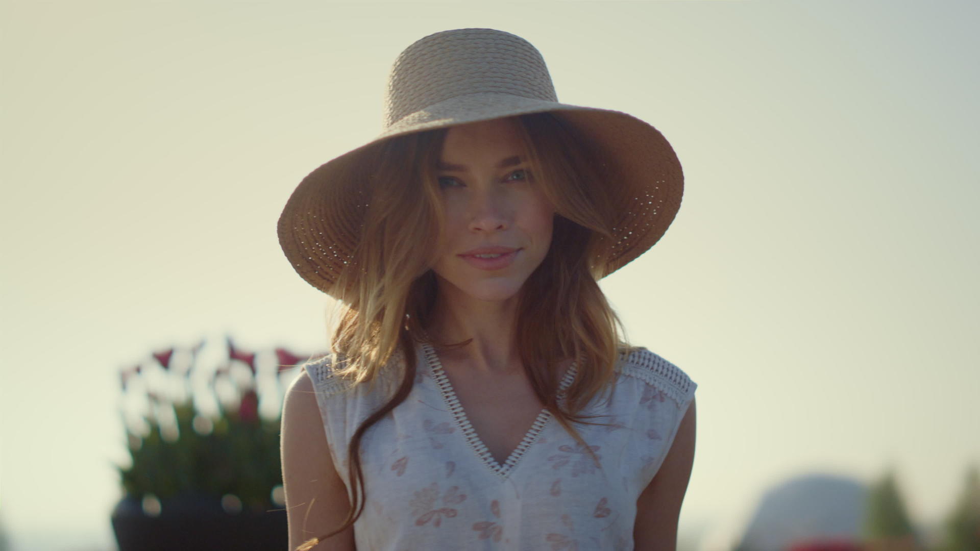 性感的金发女性戴着遮阳帽在明亮的夏天看着相机视频的预览图