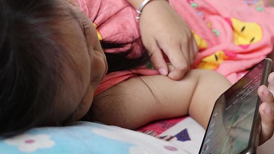 4K小孩躺着看手机危害身心健康实拍实拍视频的预览图