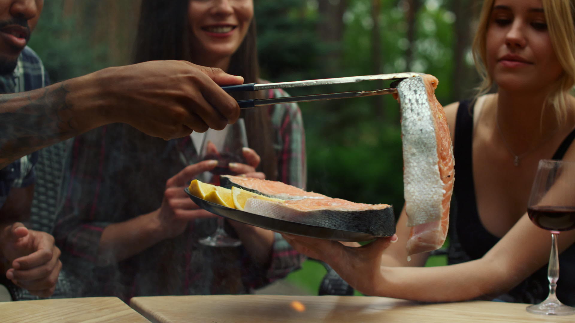 专注于帮助后院厨师的女性把鱼片放在烤架上视频的预览图
