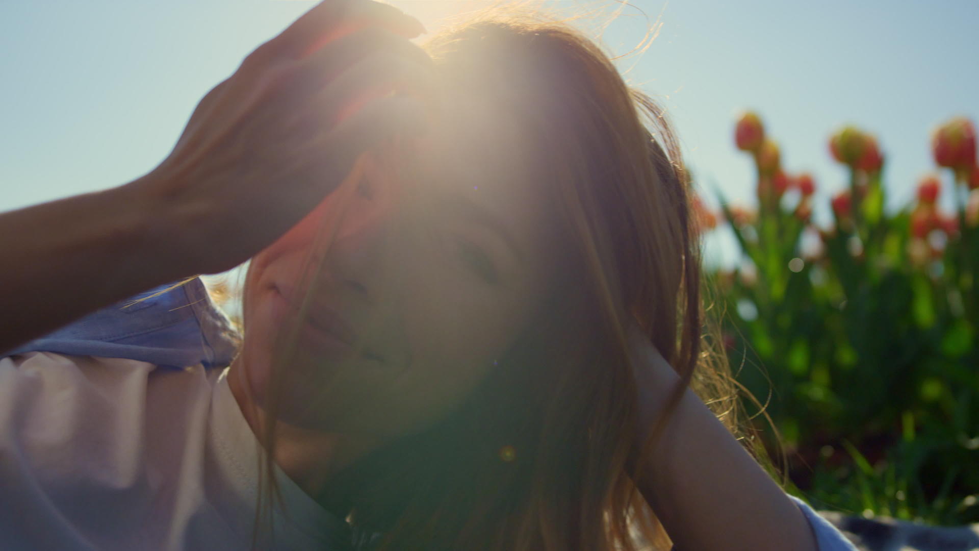 浪漫的蓝眼睛女人在柔和的阳光下放松郁金香田野的背景视频的预览图