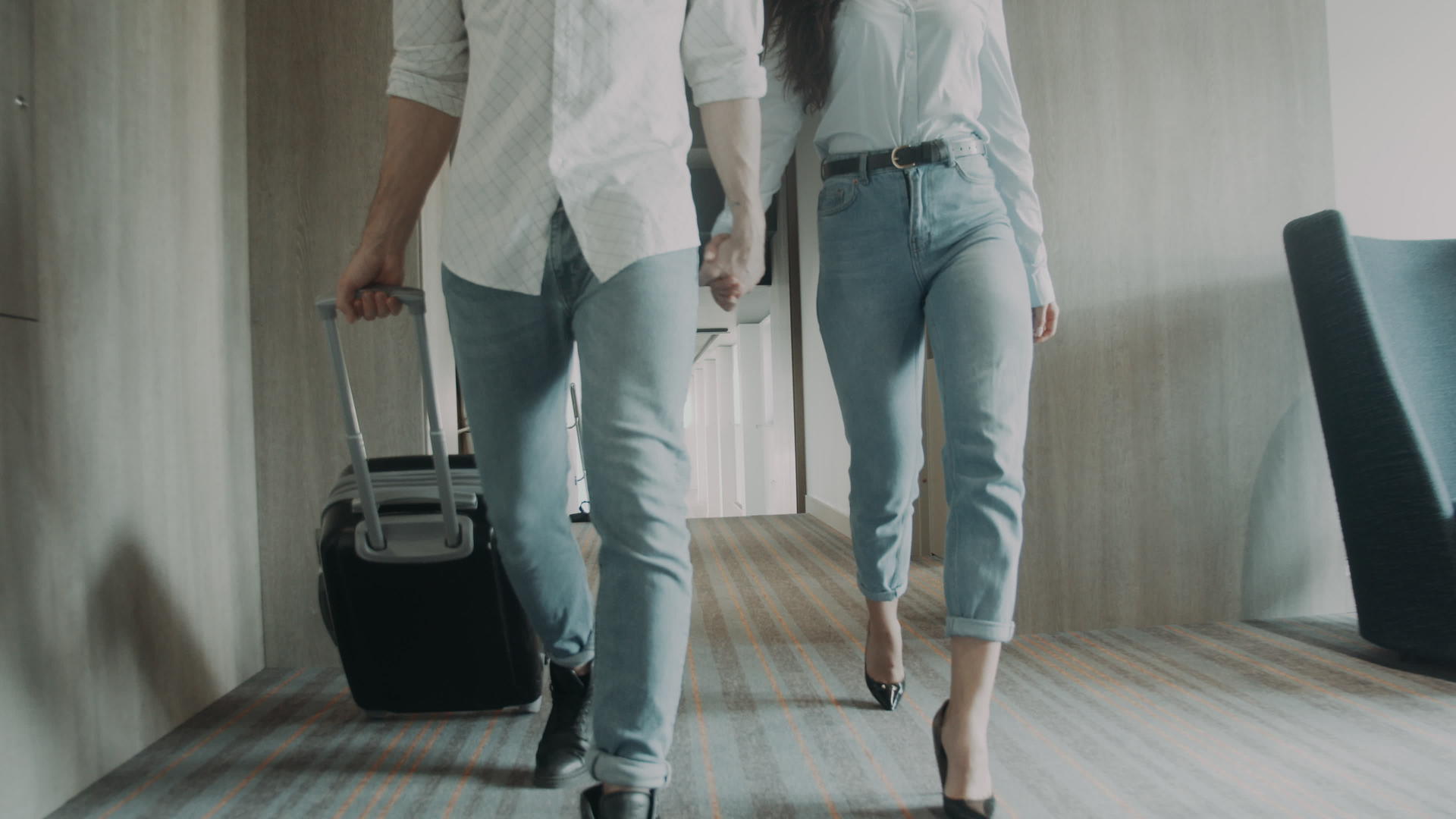 一对年轻夫妇带着行李在酒店散步视频的预览图