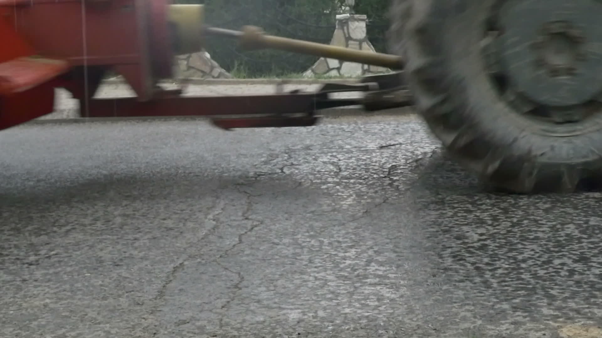 红色拖拉机在雨路上缓慢移动视频的预览图