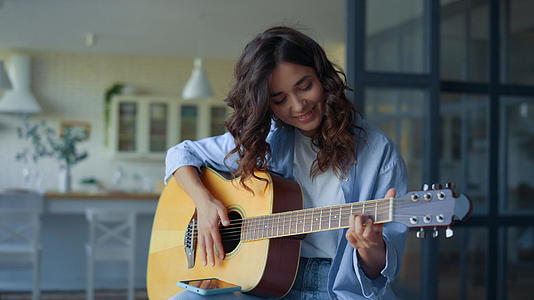 女孩弹吉他女吉他手在手机上录制吉他声音视频的预览图