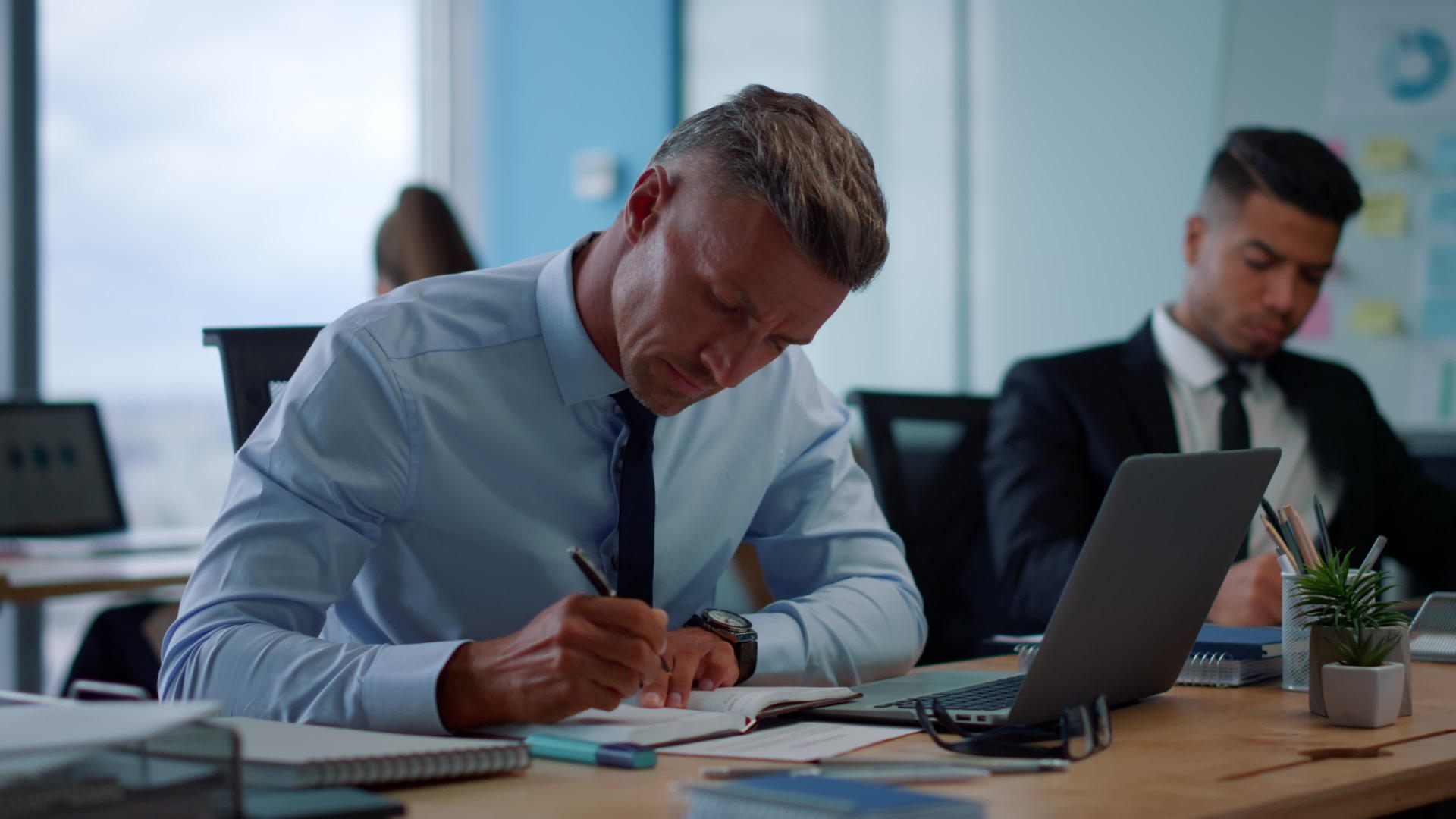重点商人在笔记本上写的男性企业家在笔记本上打字视频的预览图