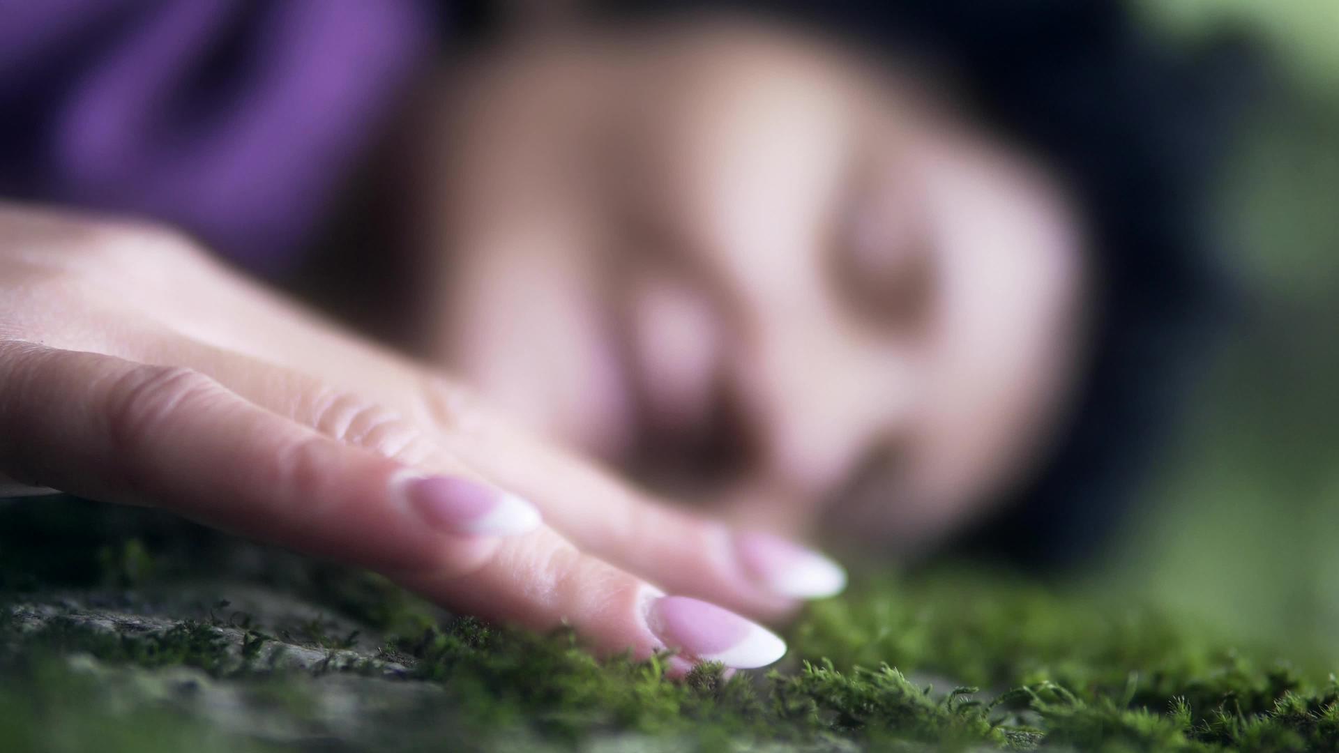 美丽的女人躺在草地上微笑着梦想着享受大自然的户外绿色苔藓视频的预览图
