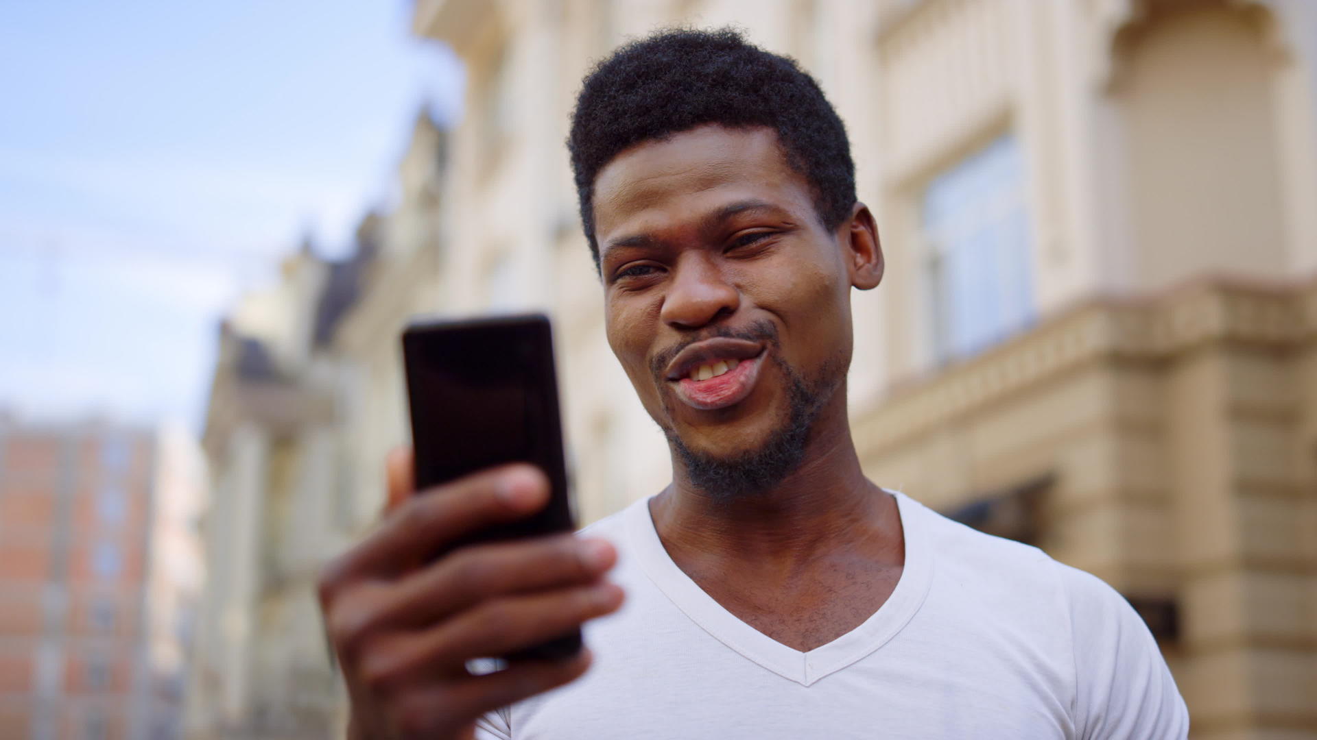 兴奋的非洲家伙在街上有视频电话男人在户外做手势视频的预览图