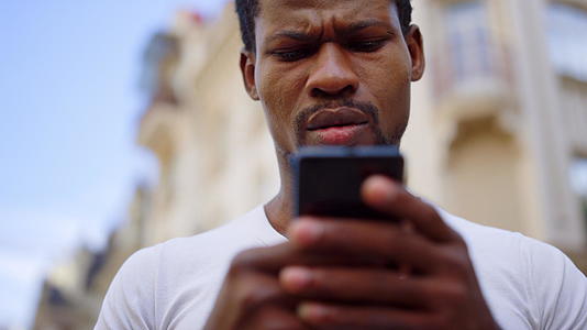 非洲人在街上使用手机男士用智能手机发短信视频的预览图