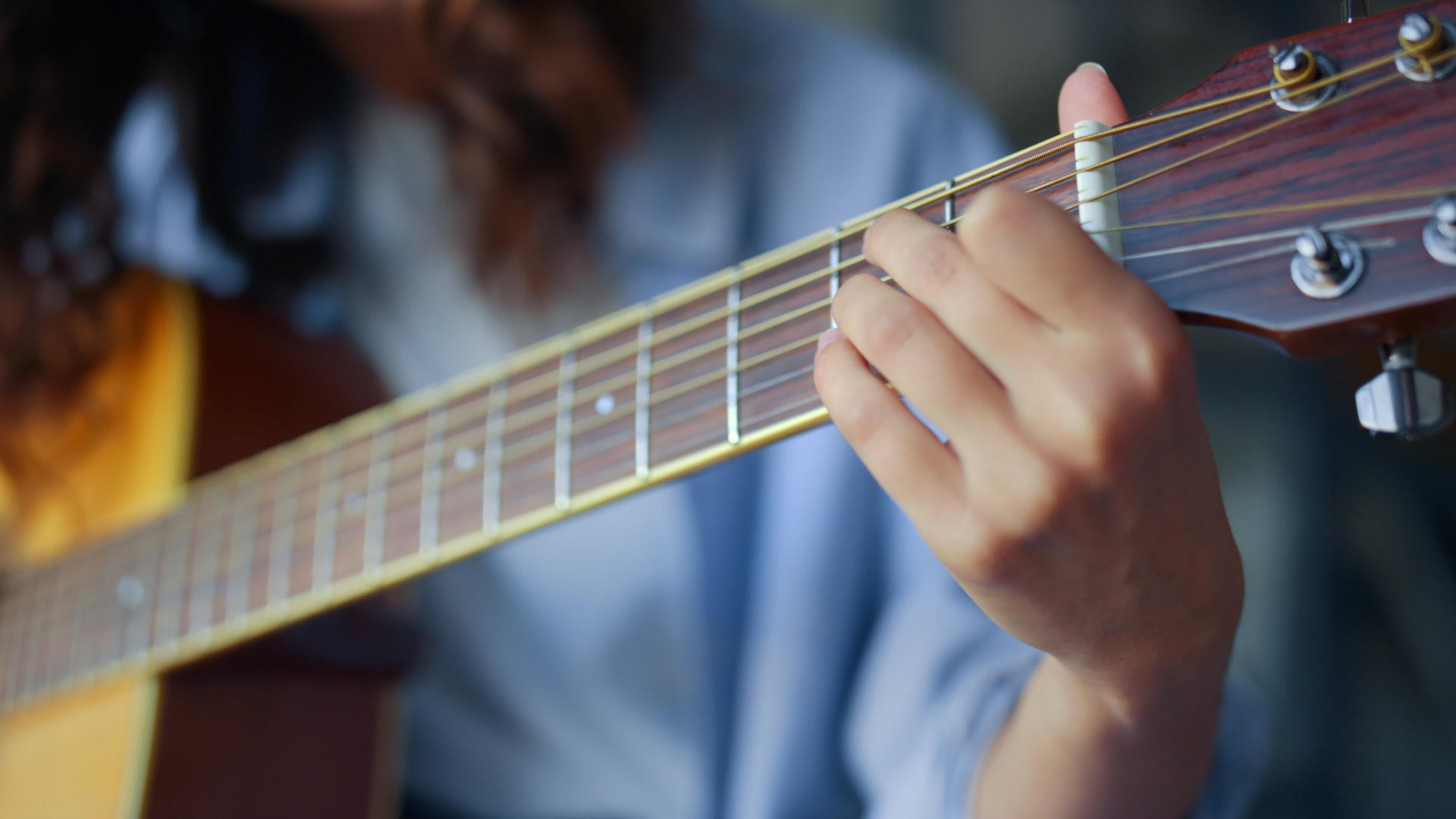 女人手在吉他上弹和弦女孩的手指在吉他上弹弦视频的预览图