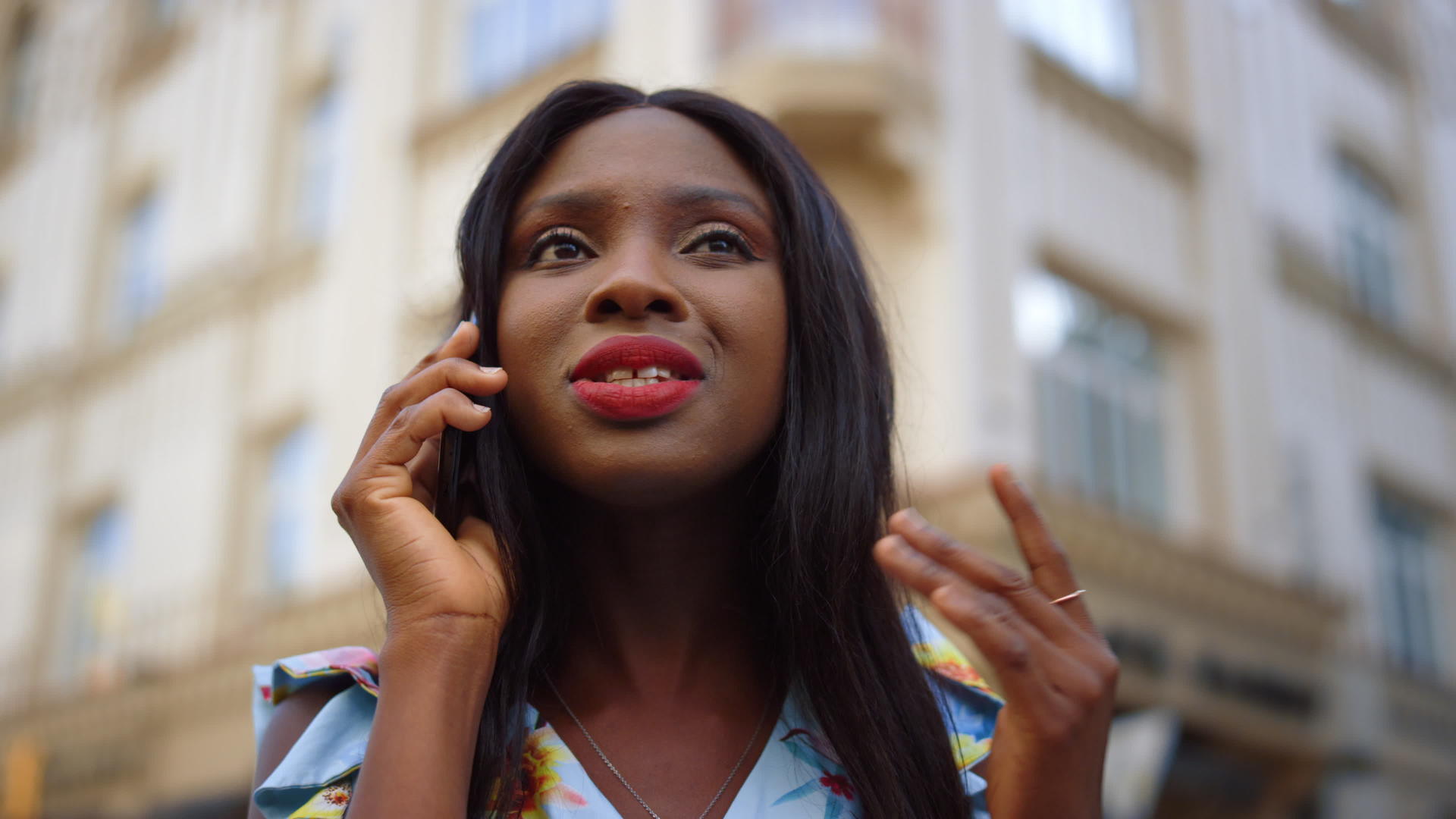 非洲女孩在街上打电话交谈在城市里女士说智能手机视频的预览图