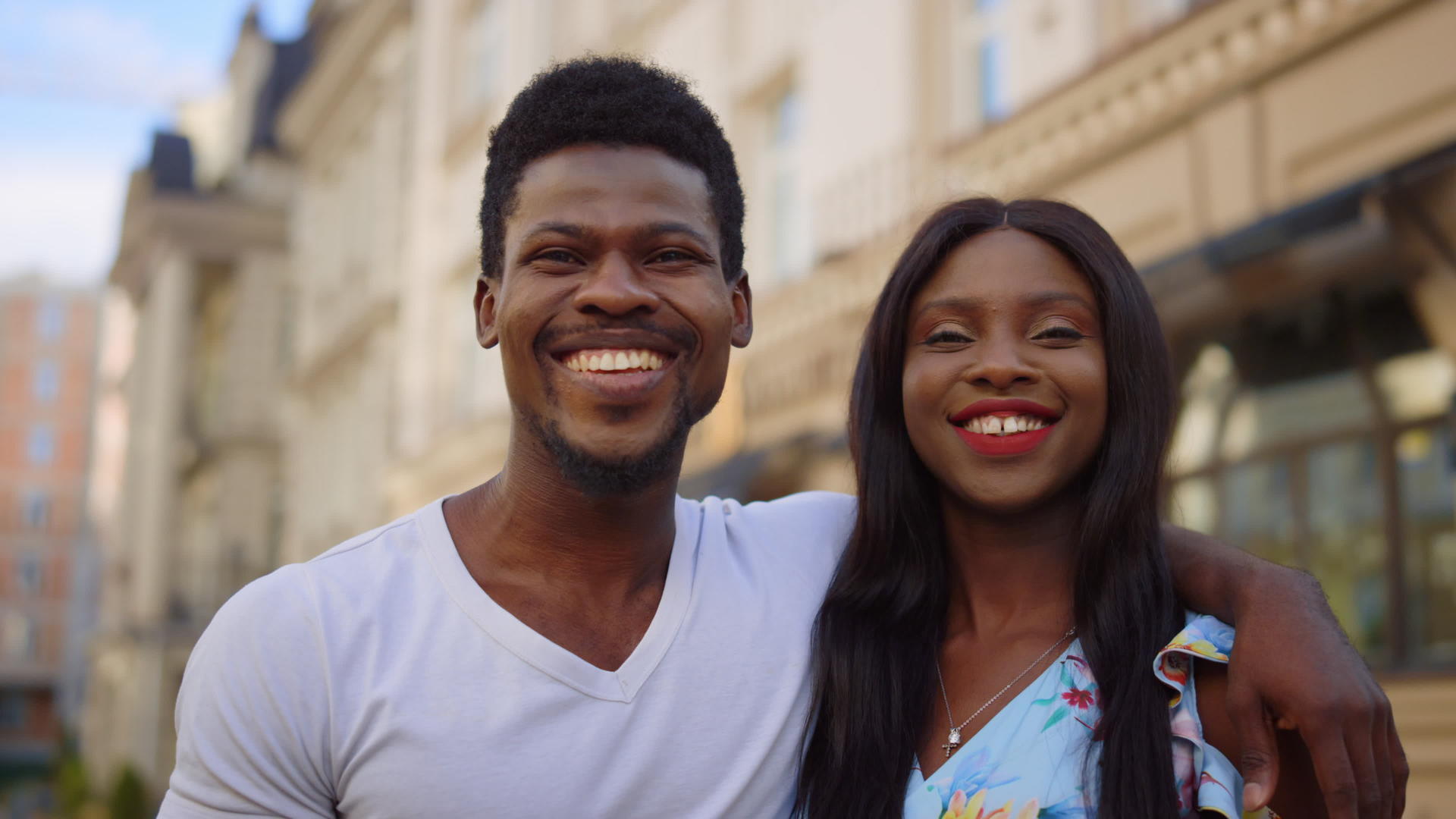 城里一对微笑的夫妇盯着镜头非洲人在街上看相机视频的预览图