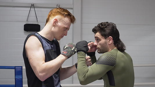 两名穿着拳击绷带的拳击手站在拳击台上准备跆拳道视频的预览图
