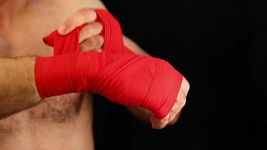 男子拳击手用红色包裹手腕视频的预览图