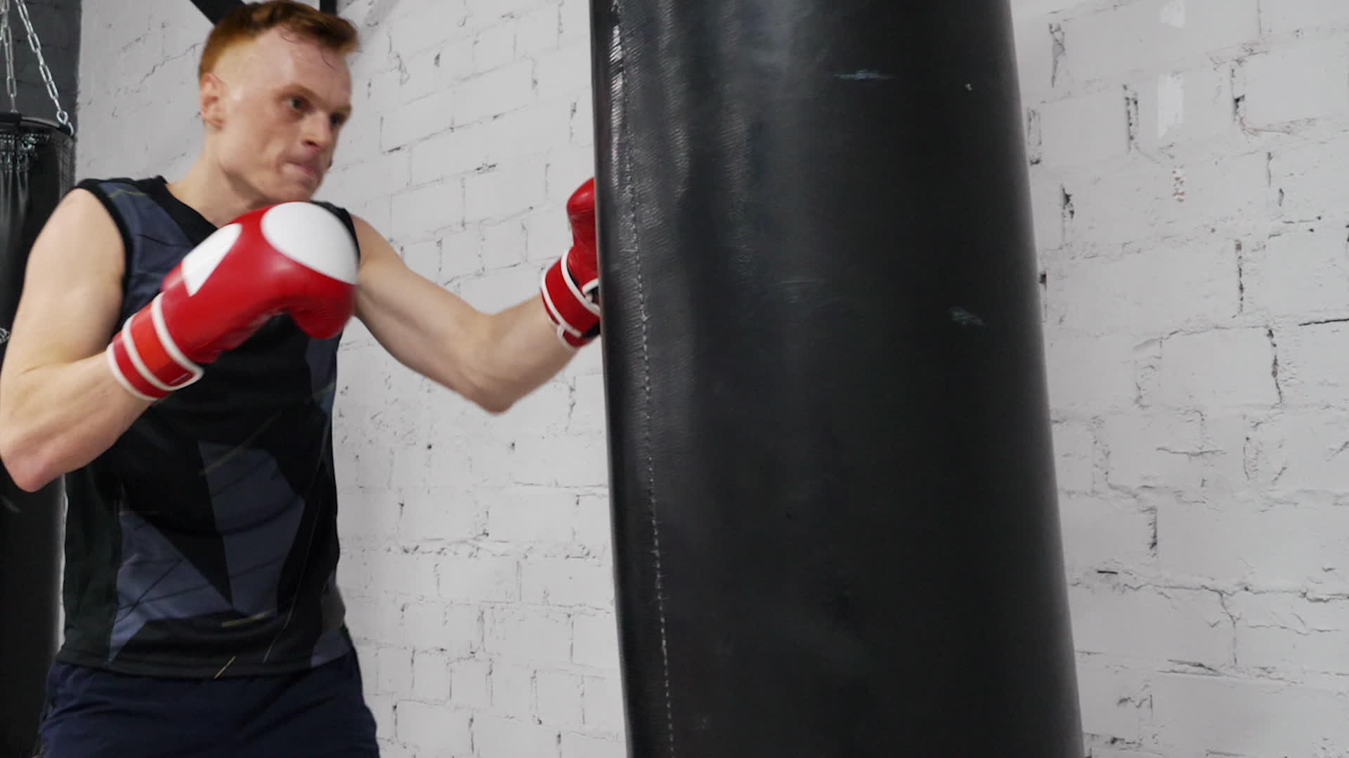 在健身房进行拳击训练时戴着手套的拳击手戴着战斗袋视频的预览图