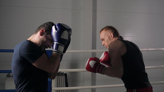 两名拳击手在拳击俱乐部的拳击台上与跆拳道运动员搏斗视频的预览图