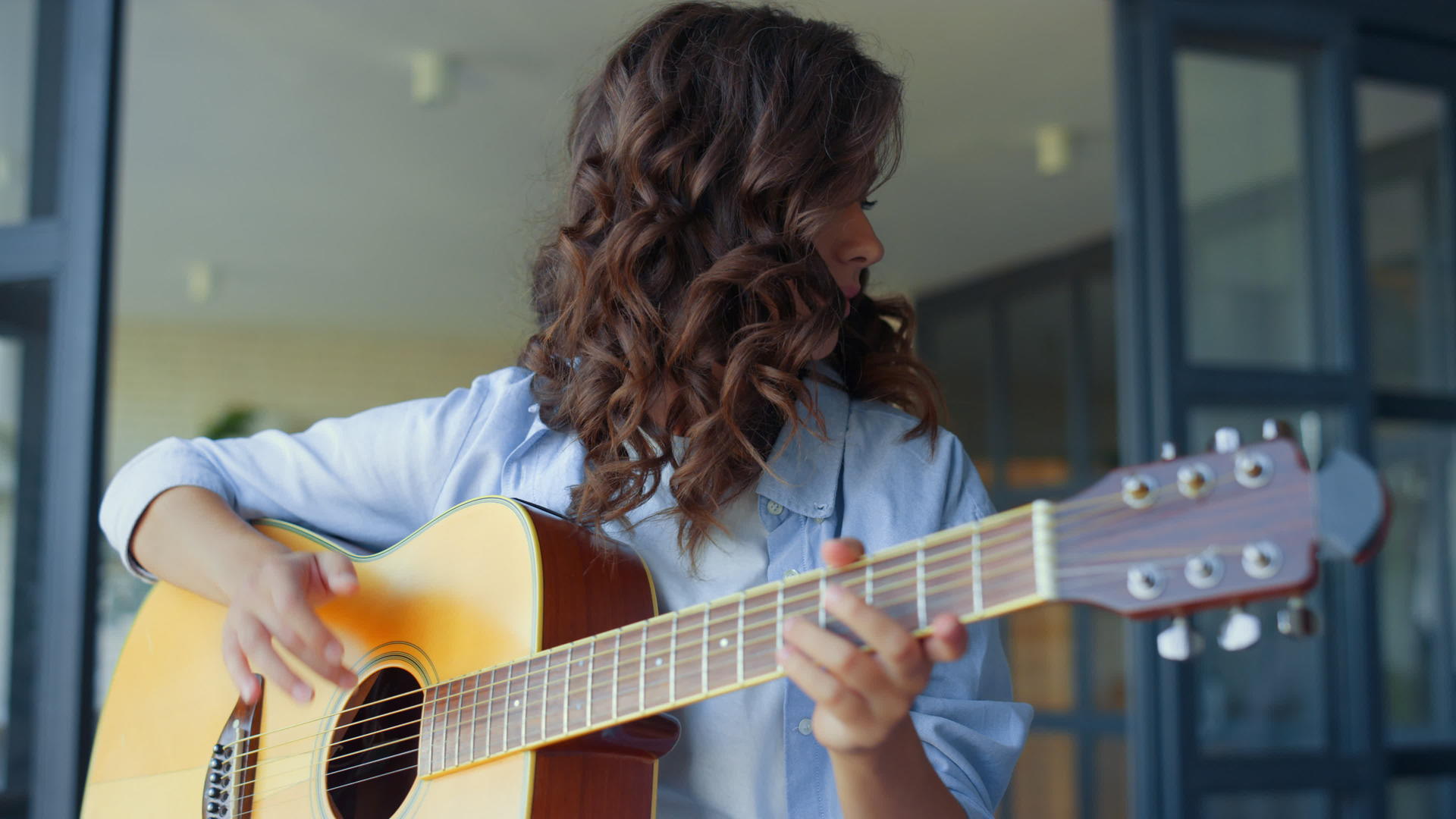 女孩在吉他上练习音乐深思的吉他手在上面创作音乐视频的预览图