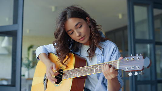 女孩在吉他上练习音乐女吉他手正在演奏和弦视频的预览图