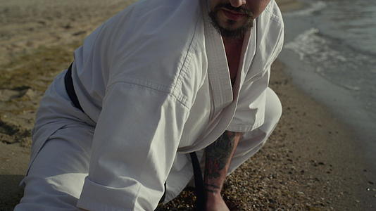 运动型男性在沙滩特写镜头上进行伸展训练视频的预览图