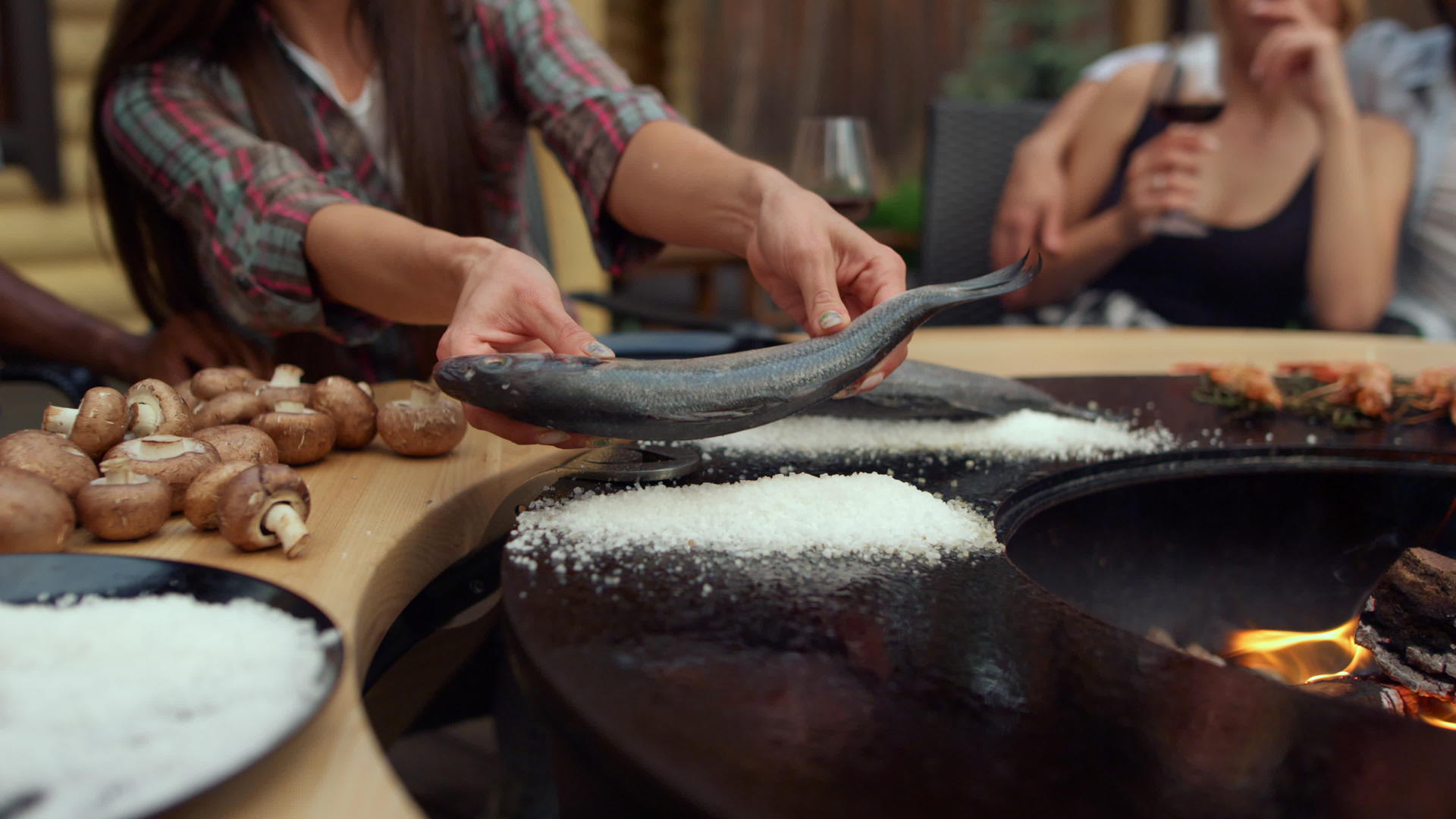 未知的女孩把鱼放在烤架上吃盐视频的预览图