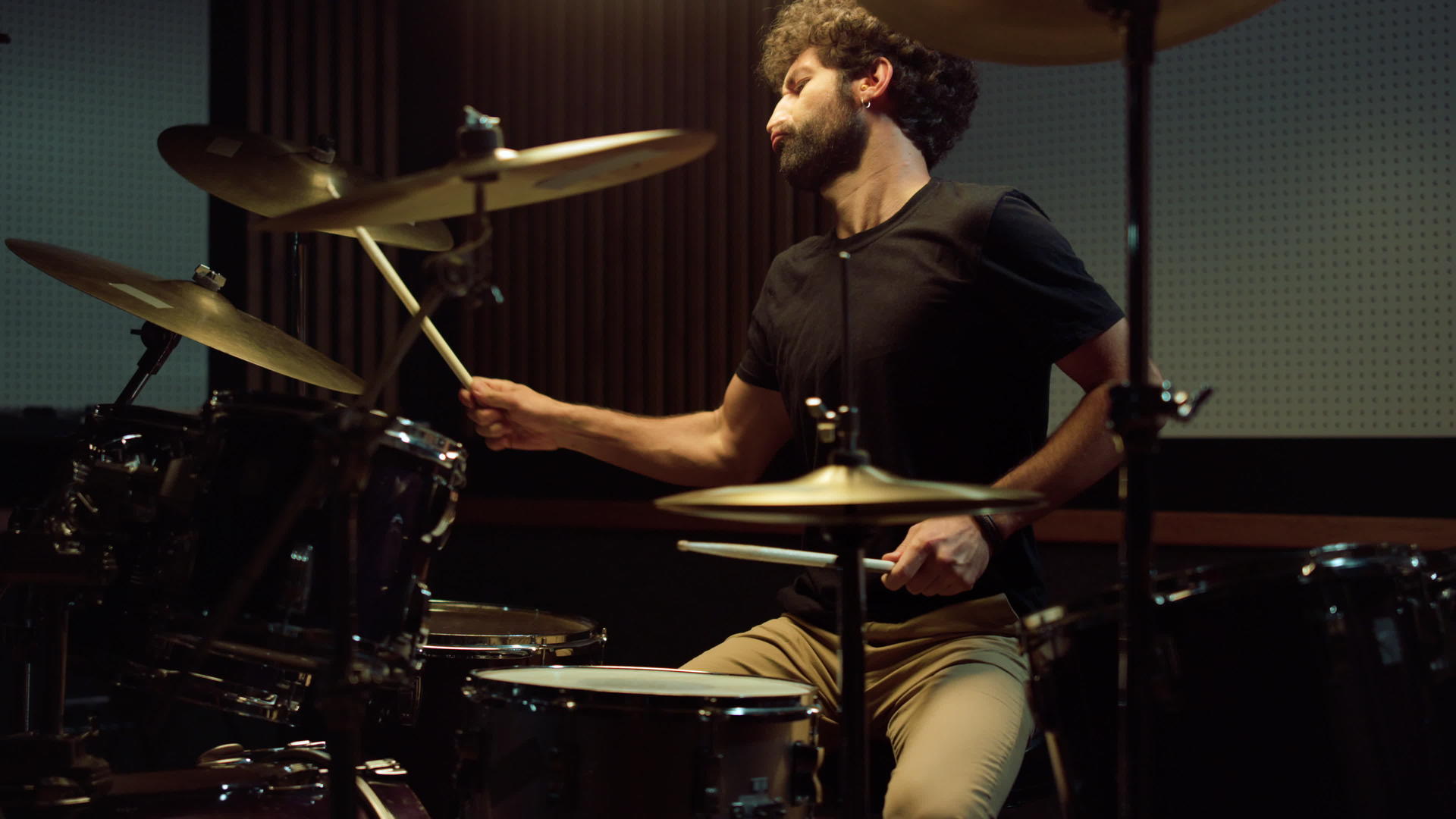 音乐厅里的摇滚音乐家鼓手在鼓套上演奏视频的预览图