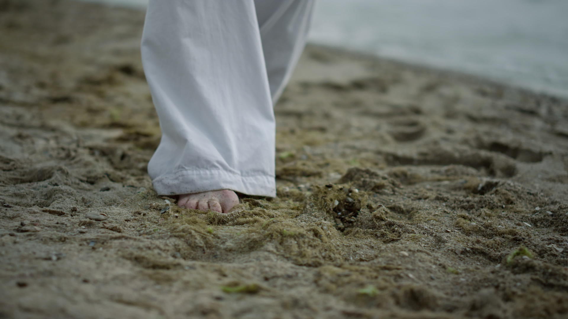 未知的赤脚人踩海滩特写镜头视频的预览图